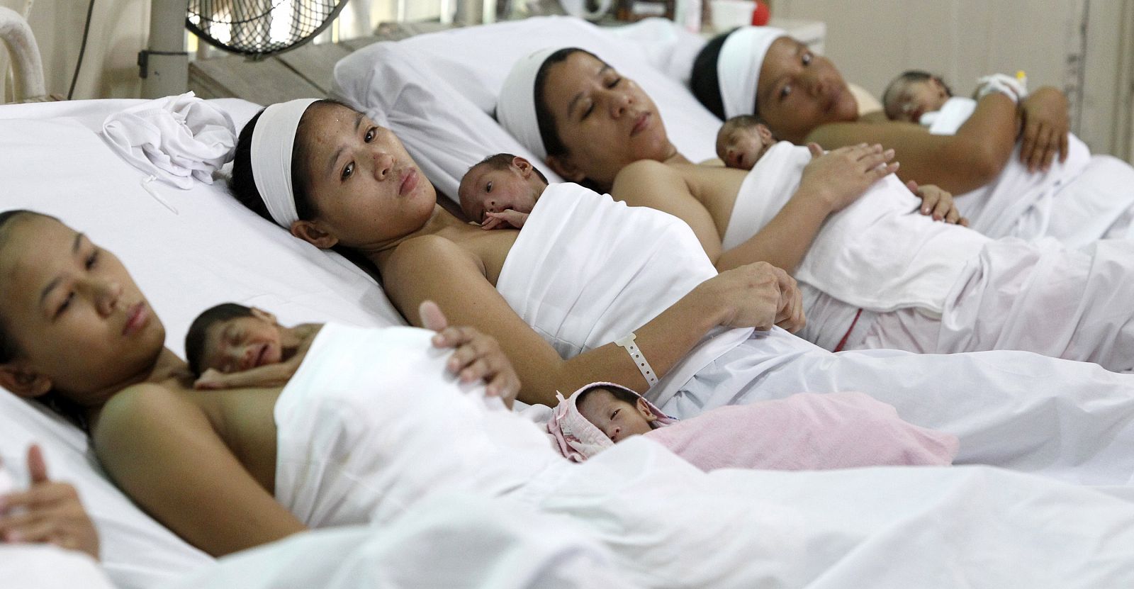 Filipino mothers tuck their babies on their chests at a ward of state-owned Fabella maternity hospital in Manila
