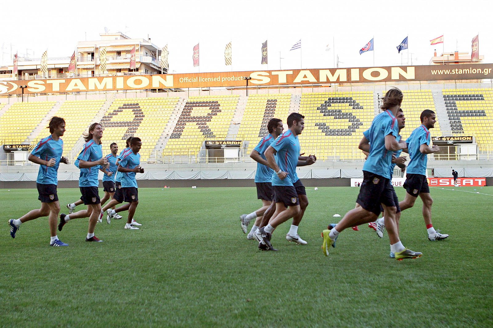 Los jugadores del Atlético de Madrid corren en el estadio del Aris de Salónica.
