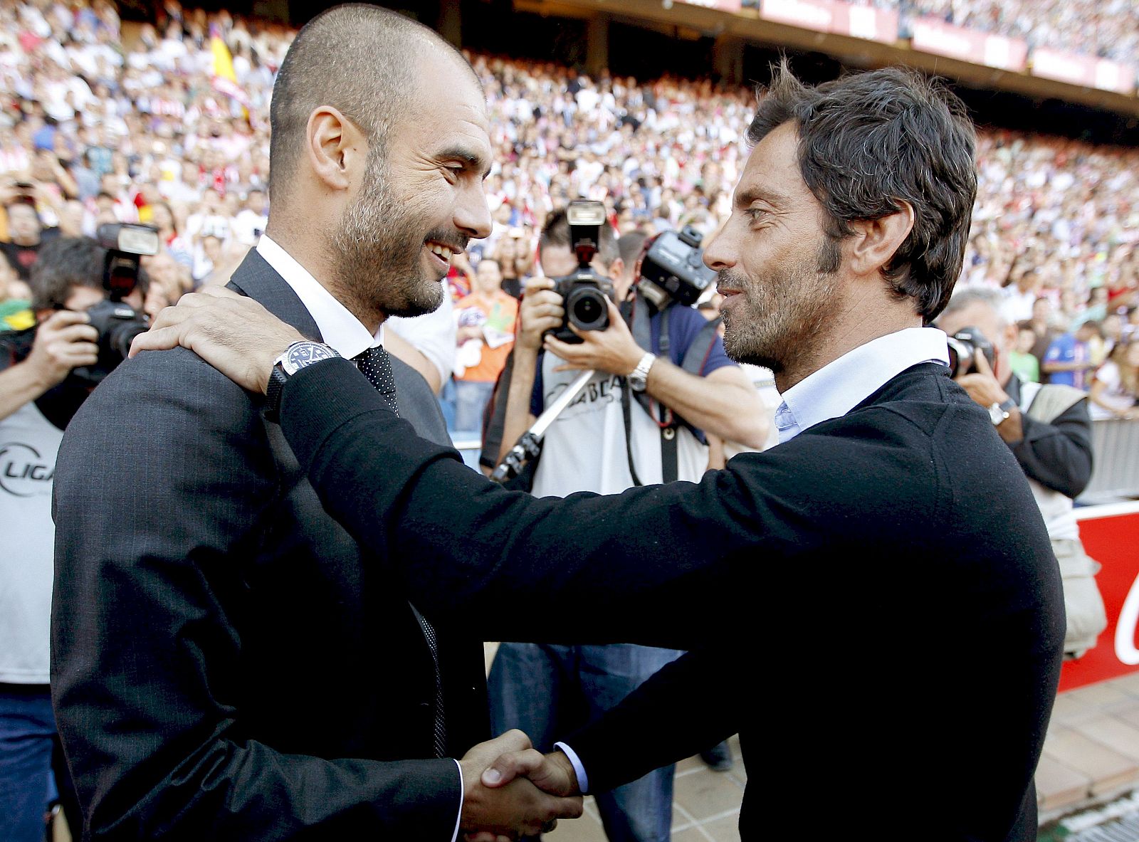 Los entrenadores Guardiola y Flores se saludan antes del partido que les enfrentó en el Vicente Calderón de la tercera jornada de la Liga en Primera División.