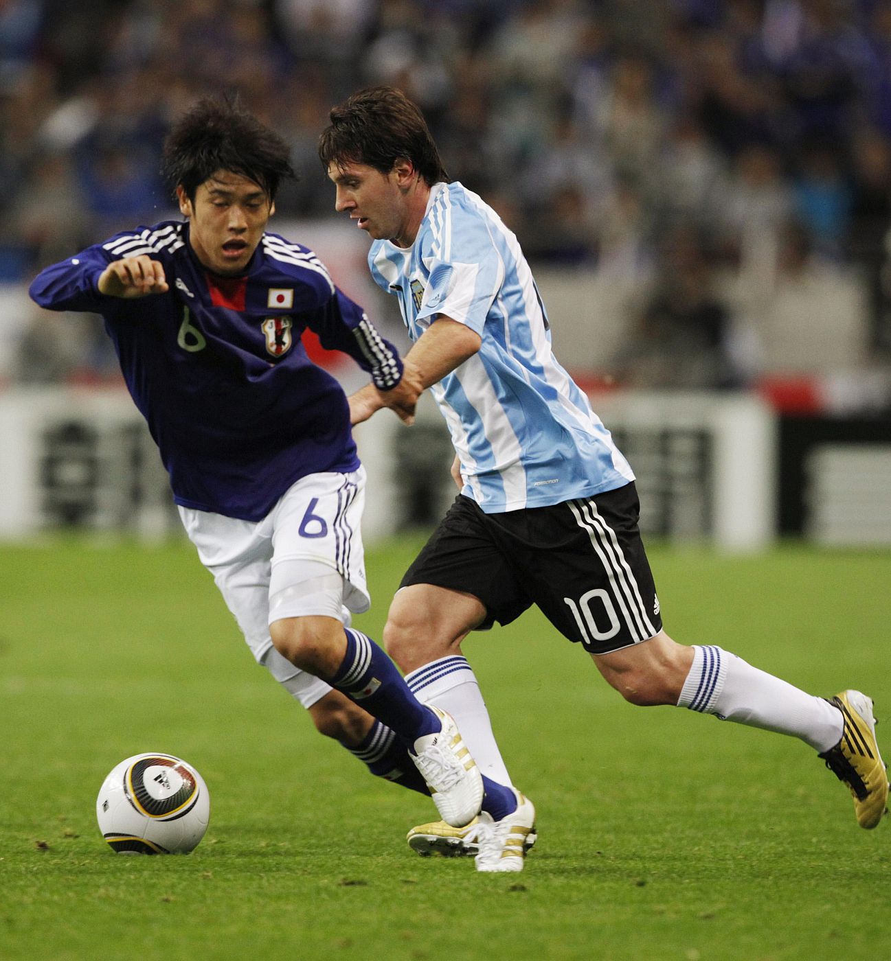 Messi disputa un balón con Uchida en un momento del partido