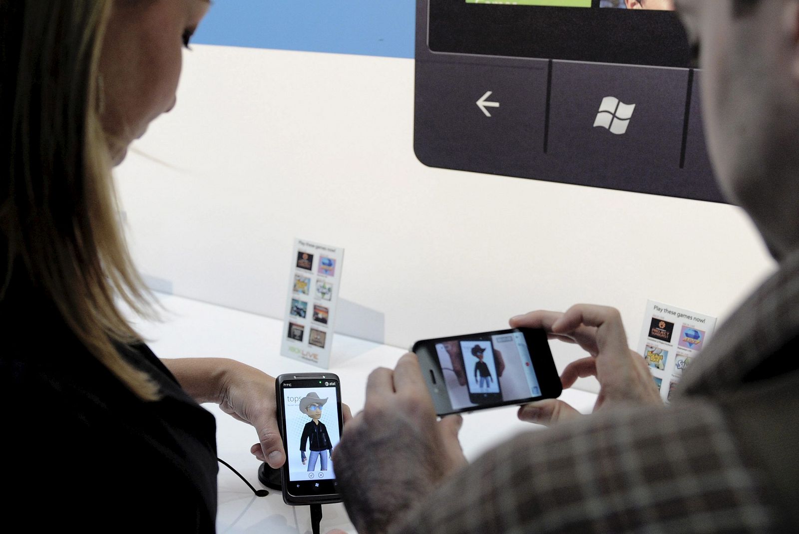 Dos asistentes prueban el nuevo sistema operativo para teléfonos inteligentes de Microsoft, el Windows Phone 7