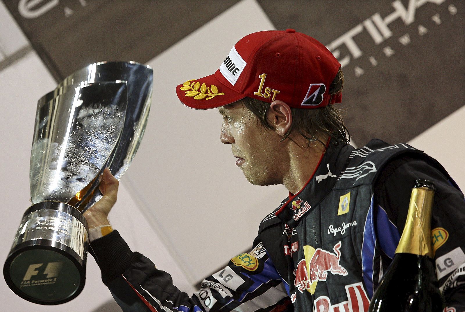 El piloto alemán de la escudería Red Bull de Fórmula Uno, Sebastian Vettel, celebra en el podio la victoria conseguida en el Gran Premio de Abu Dabi, que le vale el campeonato del mundo de 2010.