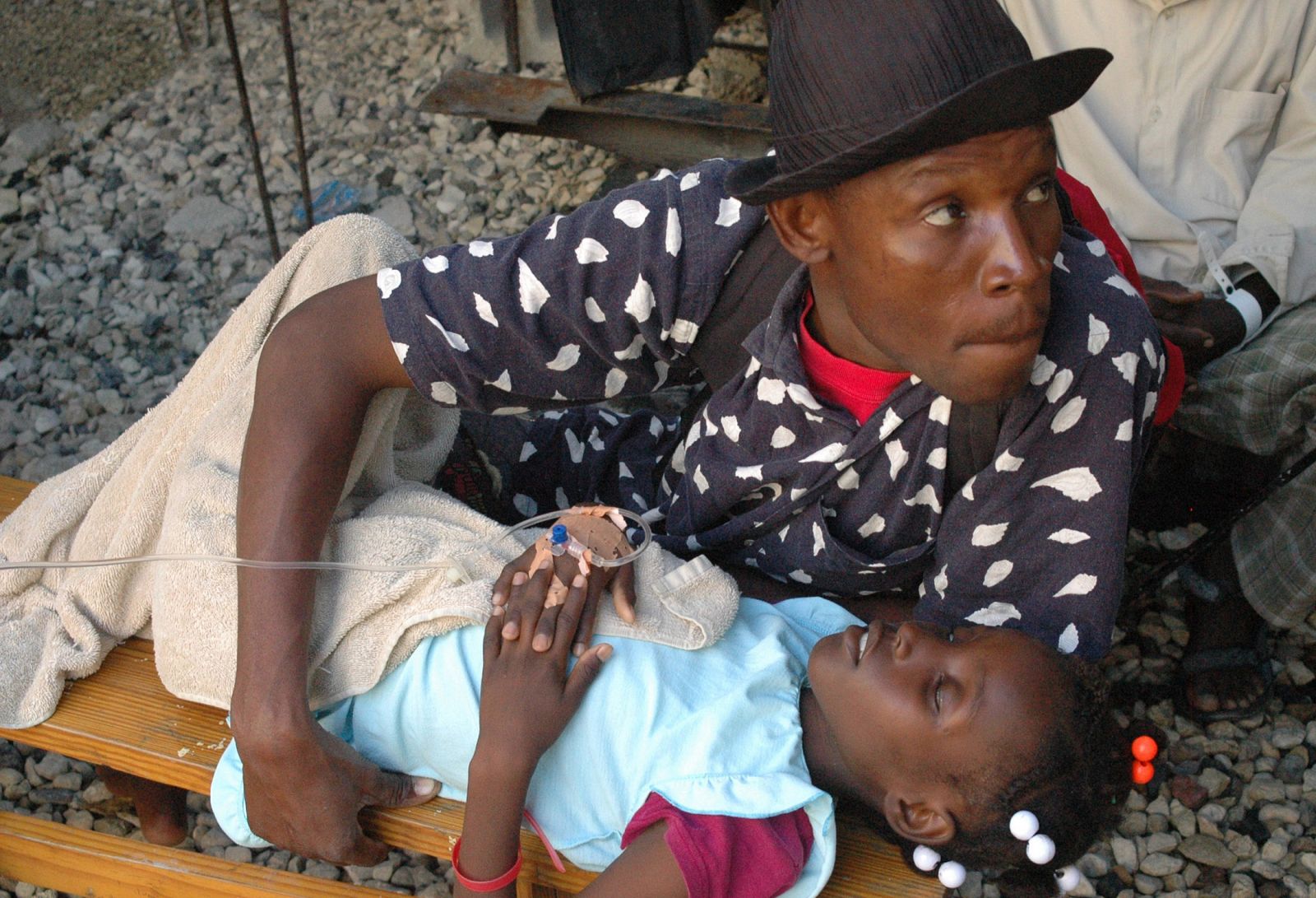 Un haitiano sostiene la mano de un familiar que sufre de cólera en un hospital de Puerto Príncipe.