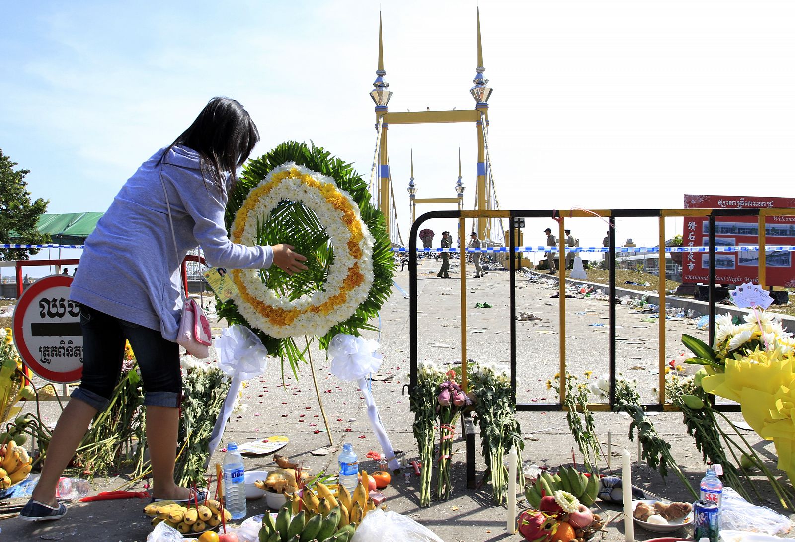 Una mujer deja su ofrenda para las víctimas de la estampida en Camboya