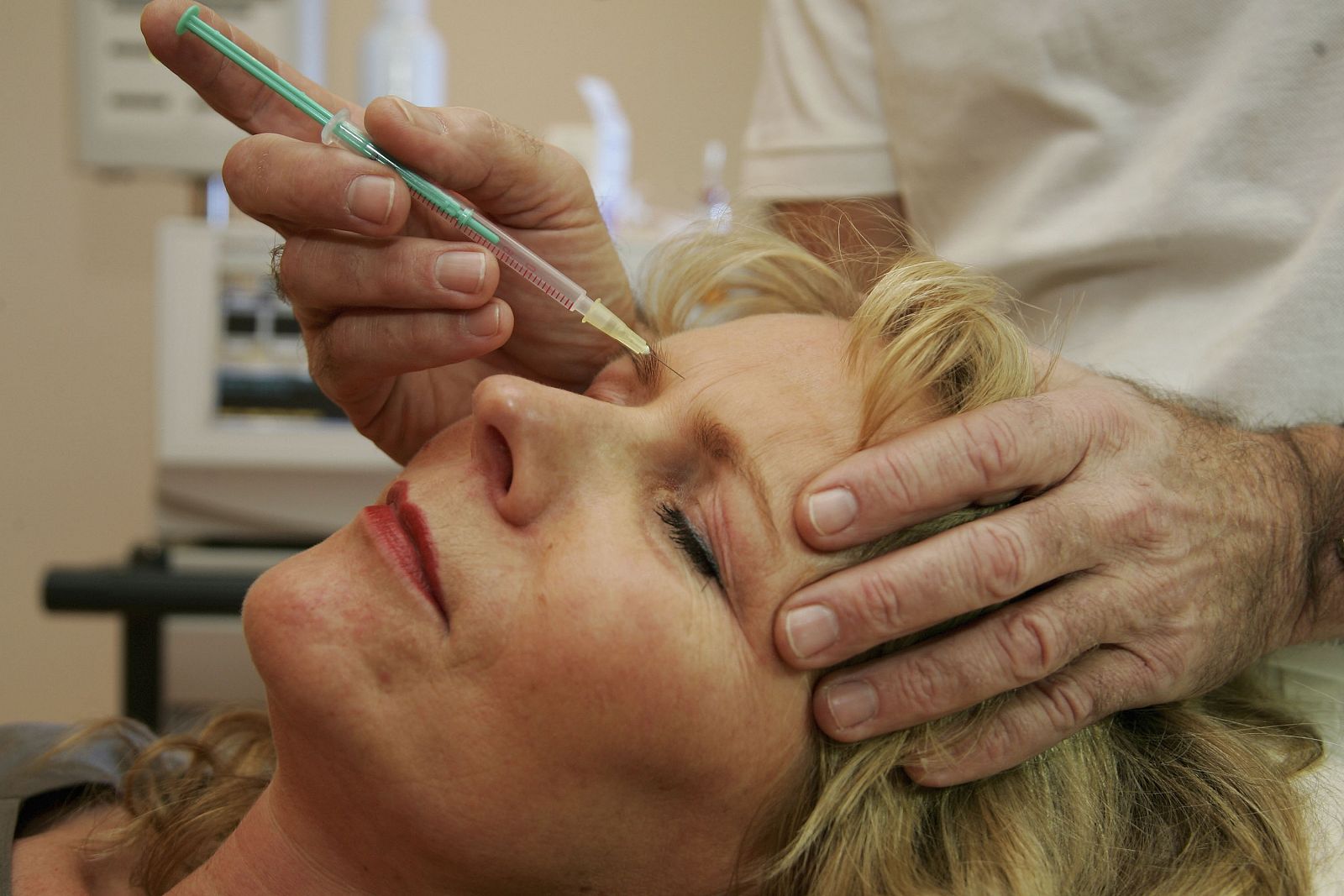 Un doctor inyecta botox a una paciente en un centro de tratamiento.