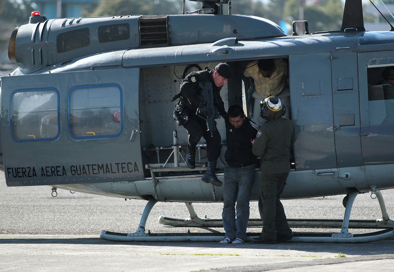 Un policía guatemalteco con un miembro de Los Zetas capturado