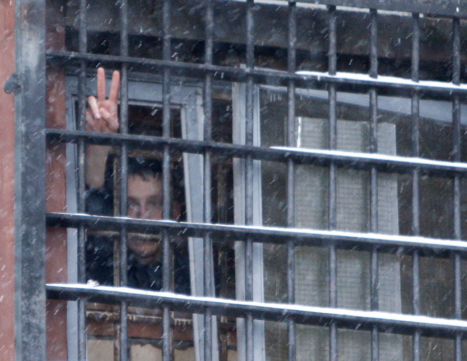 Un detenido bielorruso arrestado en las protestas hace gestos desde su celda.