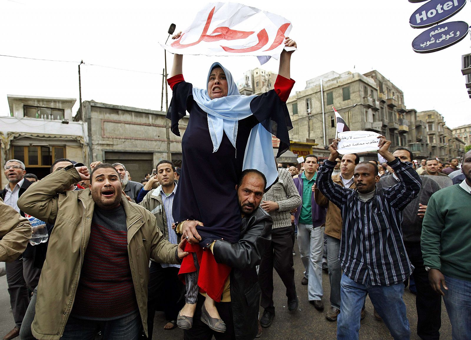 Un hombre sostiene a una mujer que grita con todas sus fuerzas contra el Ejecutivo egipcio