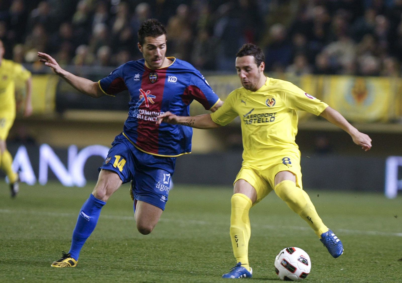 El centrocampista del Villarreal CF Santi Cazorla (d) trata de regatear al mediocentro del Levante UD Xavier Torres