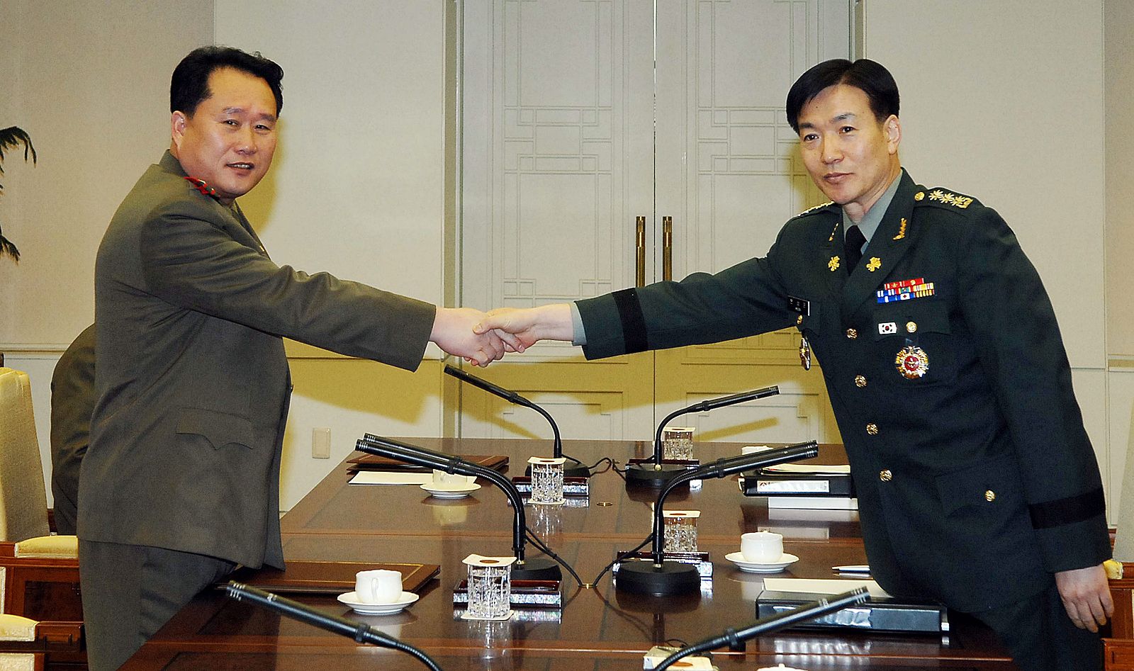 El coronel Moon Sang-gyun (d) de Corea del Sur estrecha la mano del coronel norcoreano Ri Son-kwon  en la zona fronteriza de Panmunjom, antes de su primera reunión militar de trabajo