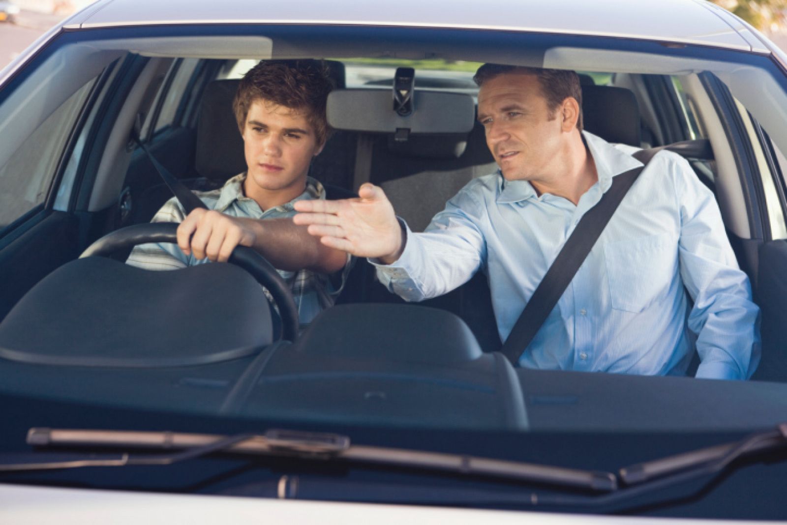 Un padre instruye a su hijo en la conducción