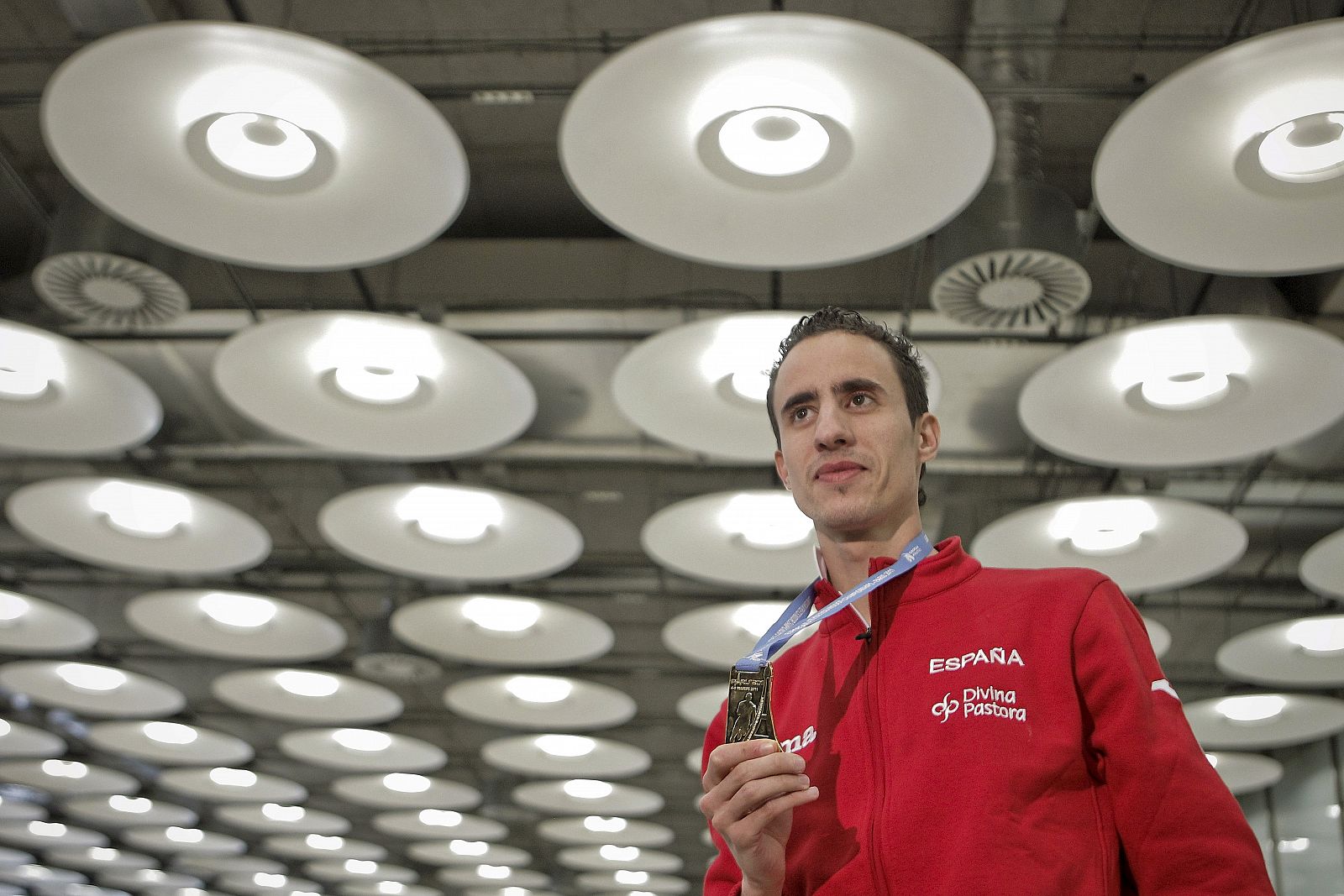 El atleta Manuel Olmedo posa con su medalla de oro a su llegada al aeropuerto de Madrid-Barajas.