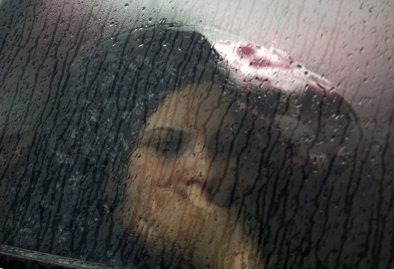 Una mujer tunecina mira la calle desde el autobús