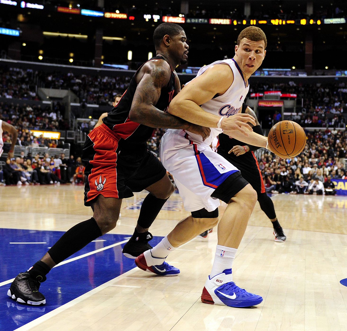 El jugador de los Clippers Blake Griffin disputa el balón con Amir Johnson de los Raptors.