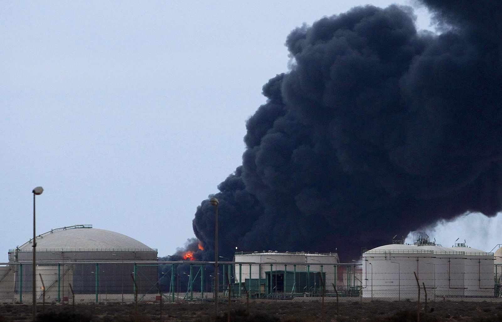 Una columna de humo sale tras un impacto en la refinería de petróleo de Ras Lanuf (Libia)