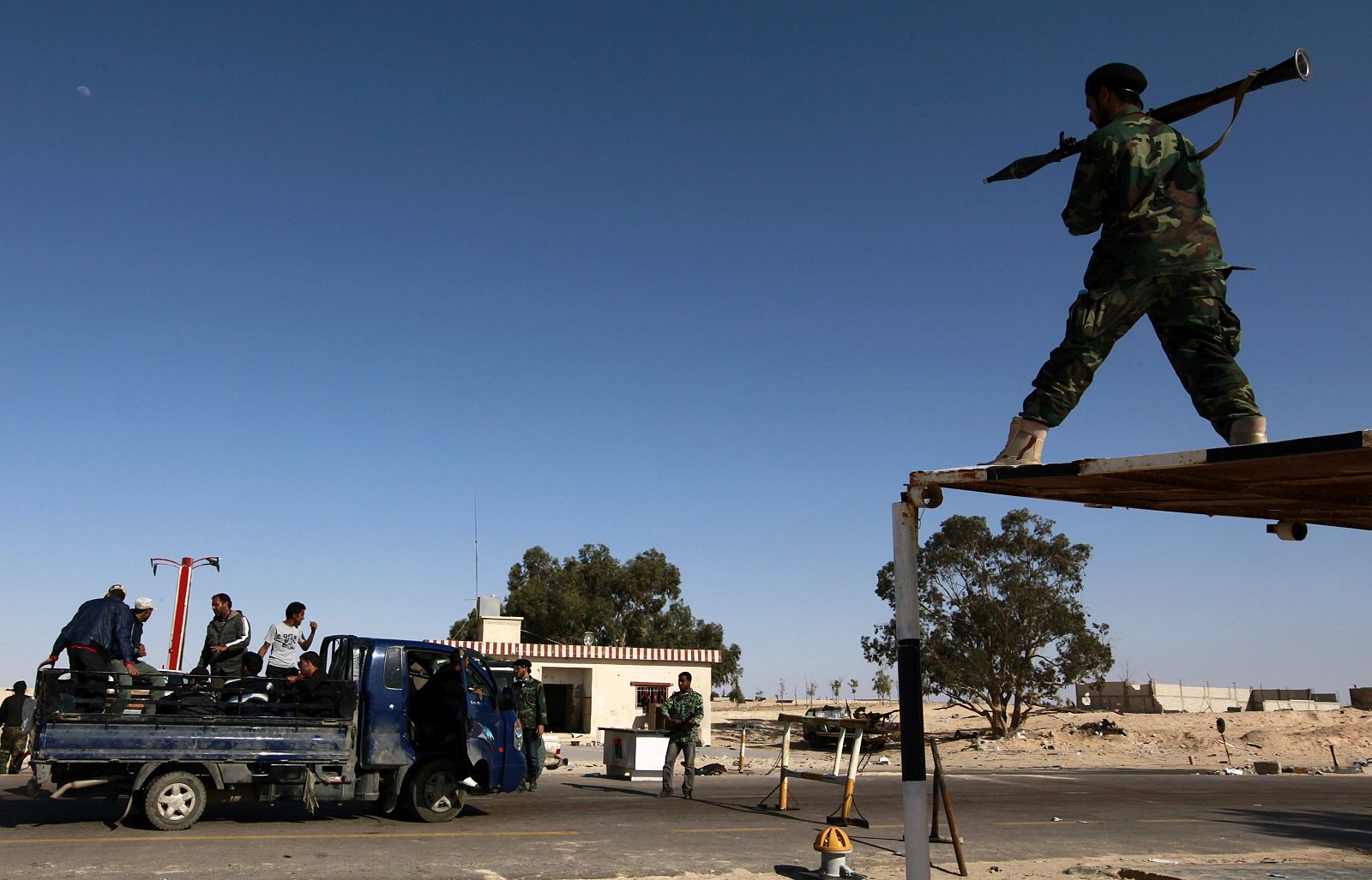 Un combatiente rebelde libio apunta  a un vehículo con su RPG (granada) un en un control de carretera en Zuwaytinah, unos 100 kilómetros de Bengasi