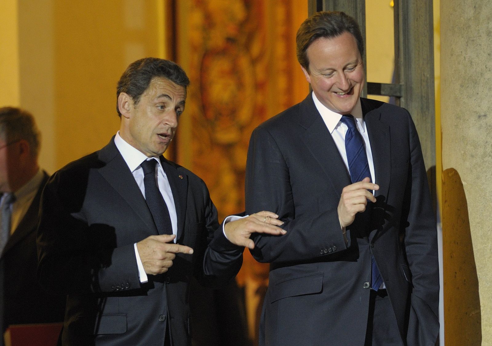 El presidente francés, Nicolás Sarkozy, charla con el primer ministro británico, David Cameron, en las escaleras del Elíseo