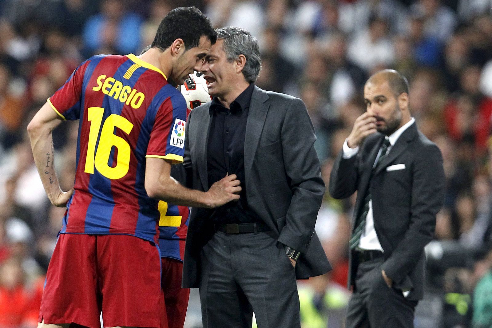 José Mourinho (c), conversa con el centrocampista del FC Barcelona Sergio Busquets (i) ante la mirada del técnico blaugrana, Pep Guardiola.