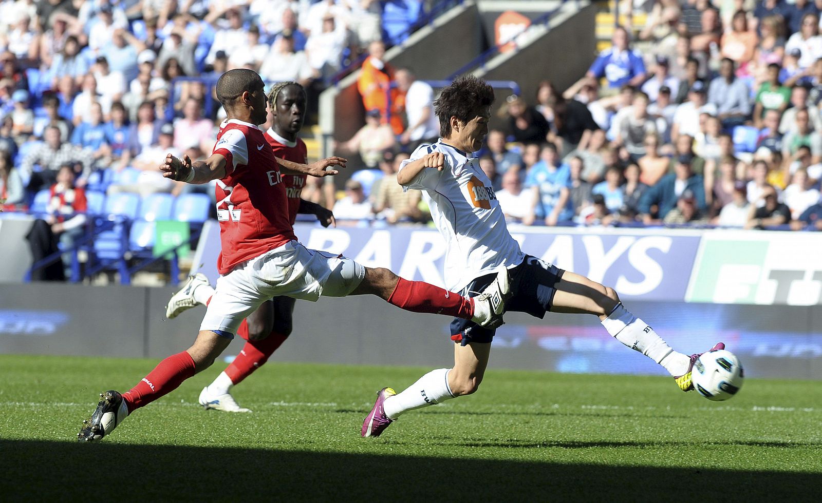 Chung-Young Lee del Bolton Wanderers (d) se disputa el control del balón con Gael Clichy del Arsenal