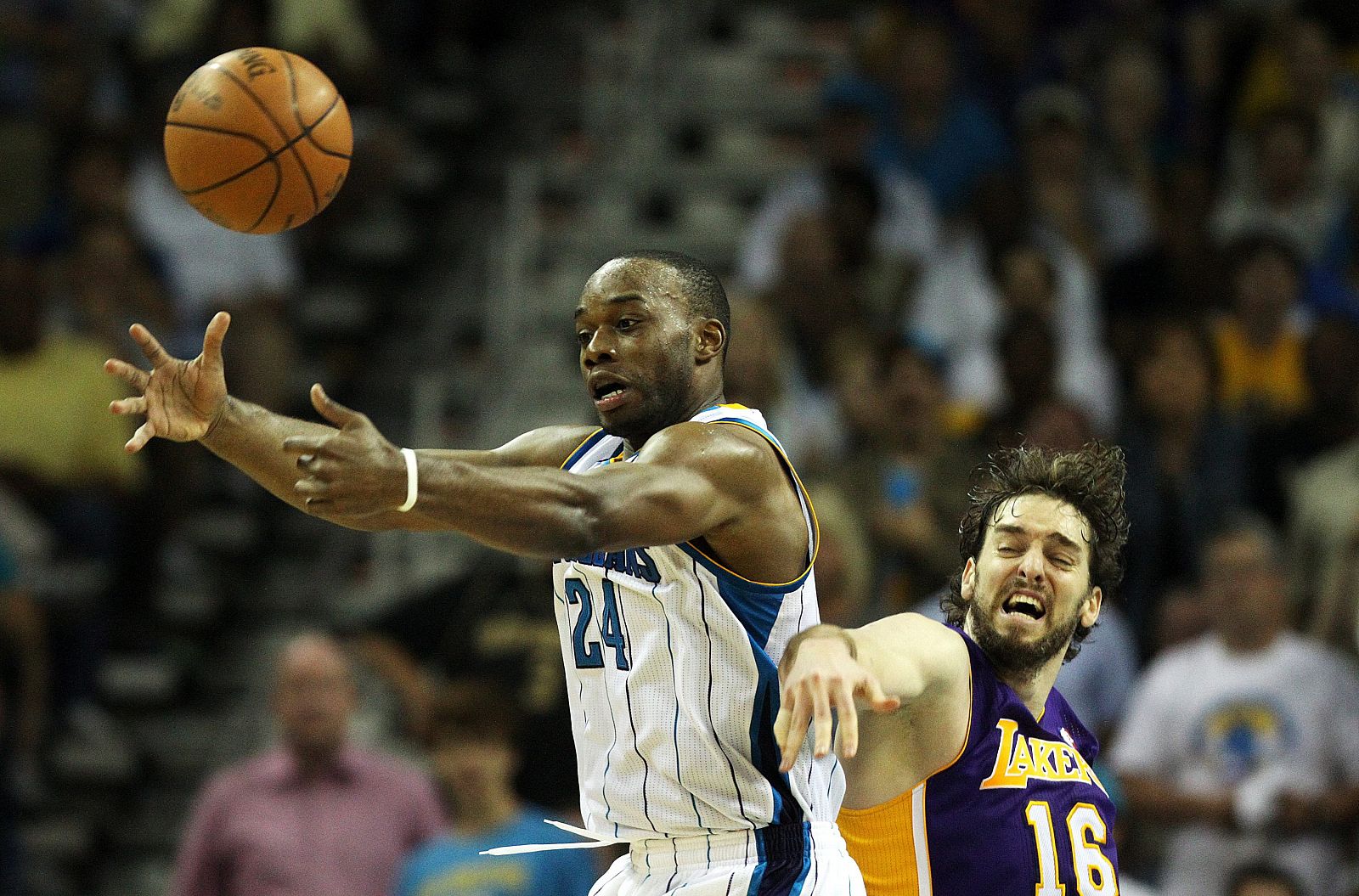 El jugador de los Hornets Carl Landry disputa un balón con Pau Gasol de los Lakers.