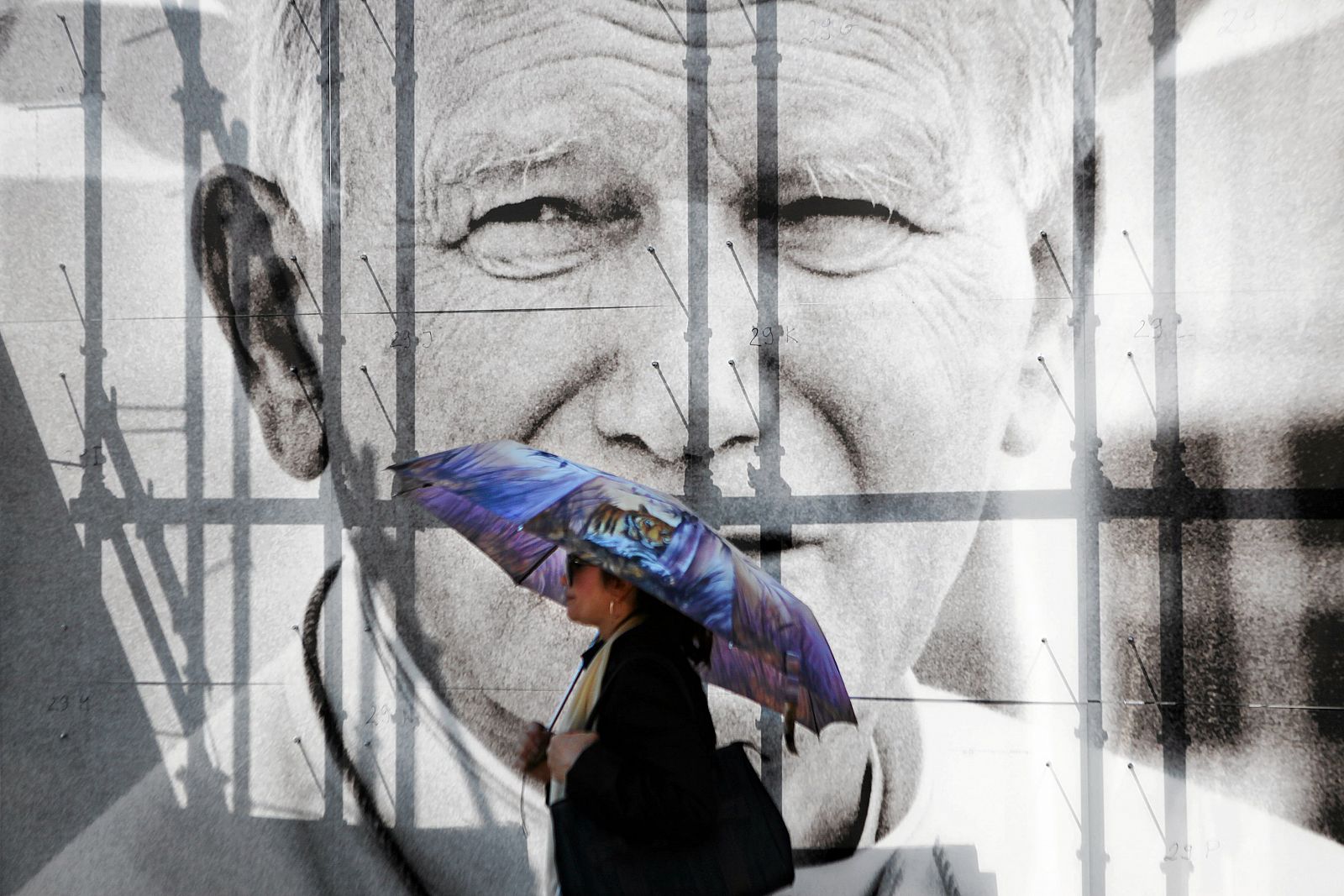 Una mujer pasa frente a un cartel con la fotografía de Juan Pablo II en Cracovia