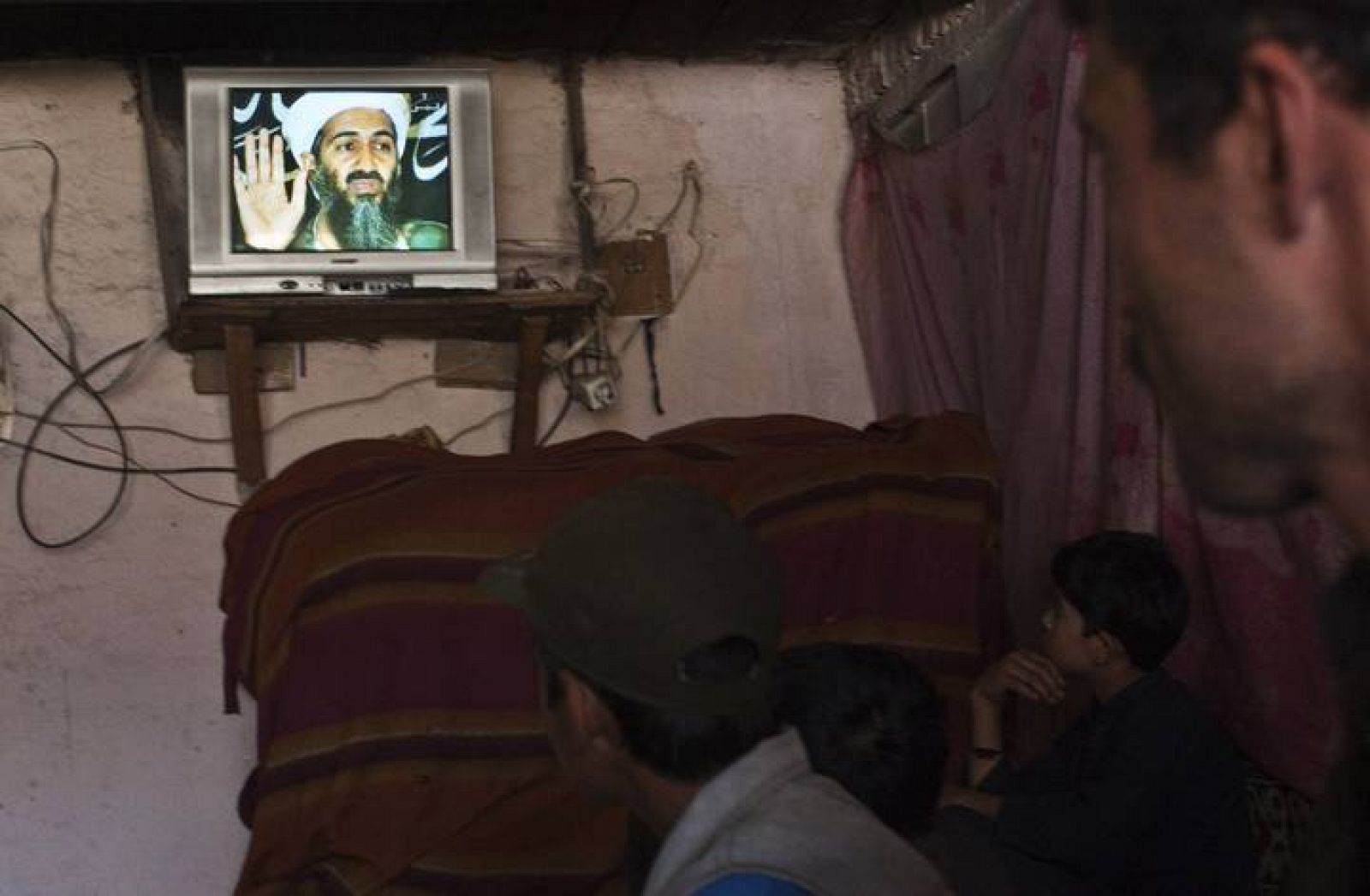 Locals watch an Afghan local television channel news telecast about Osama Bin Laden's death, at a resturant in Kabul