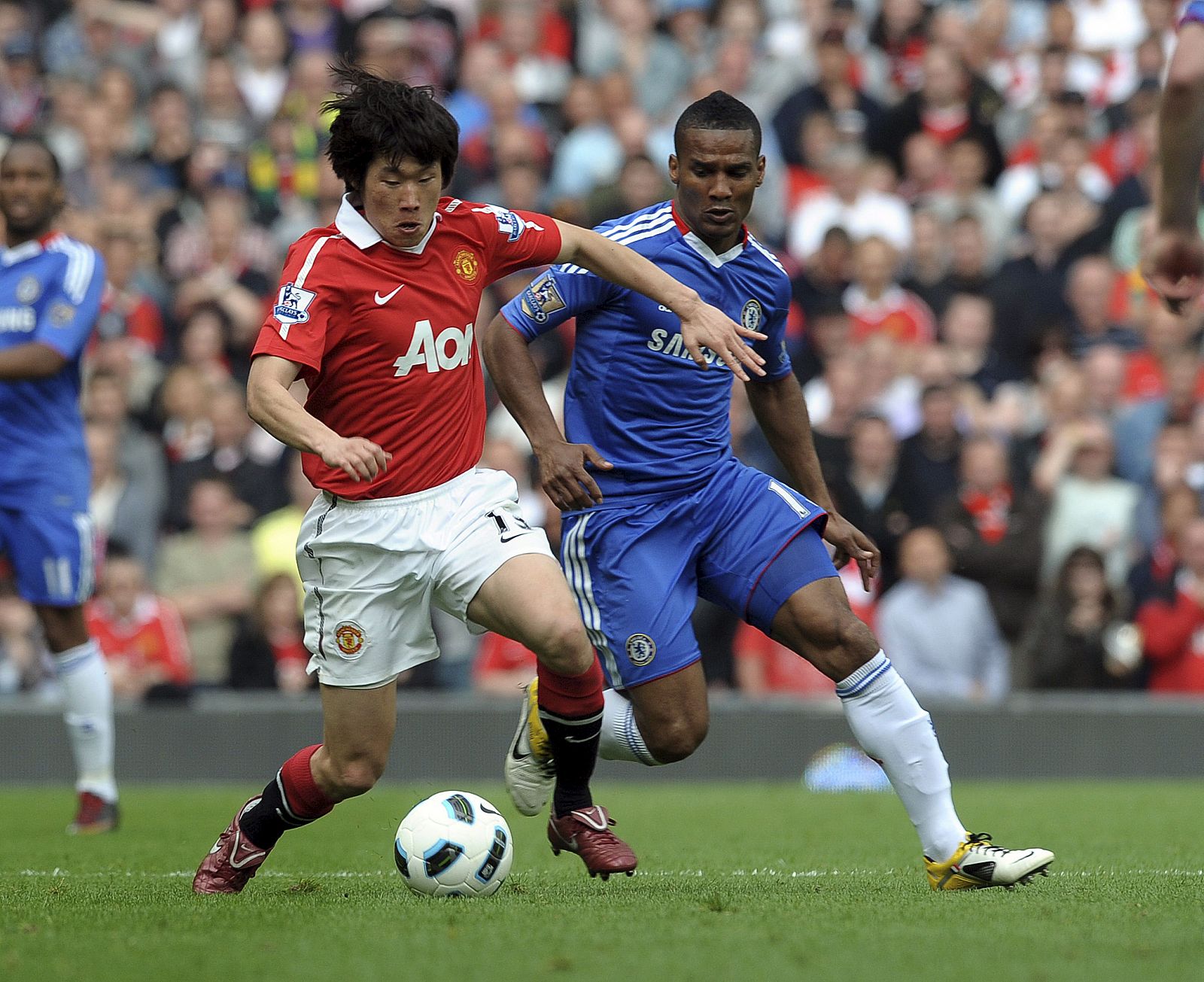Ji-Sung Park del Manchester United frente a Florent Malouda (d) del Chelsea durante el partido de Premier.