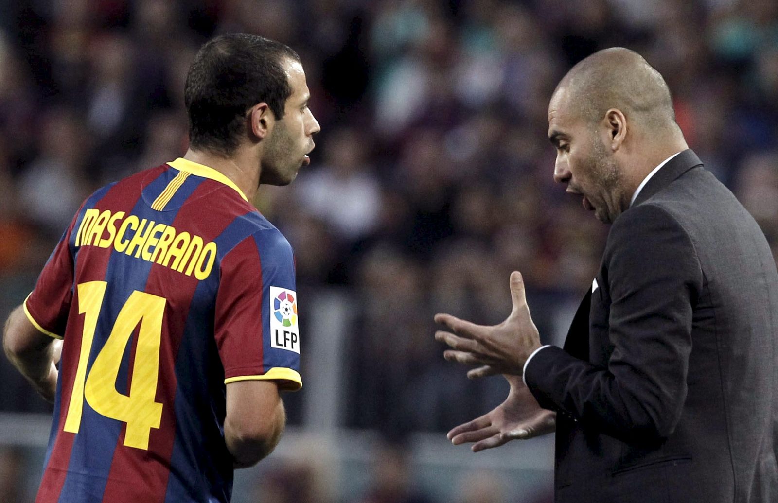 El entrenador del FC Barcelona, Pep Guardiola, da instrucciones a Mascherano ante el Depor.