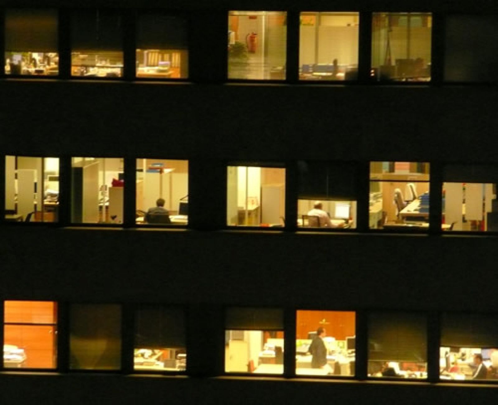 Un bloque de oficinas a pleno rendimiento durante la noche.