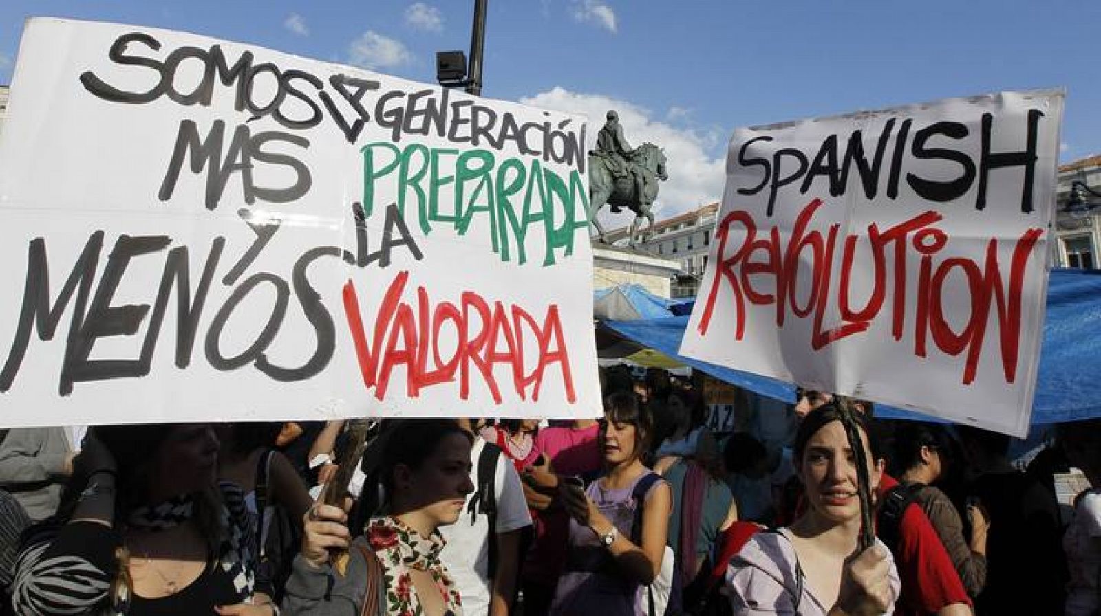 Manifestantes del movimiento 15-M portan carteles este viernes por la tarde en la Puerta del Sol