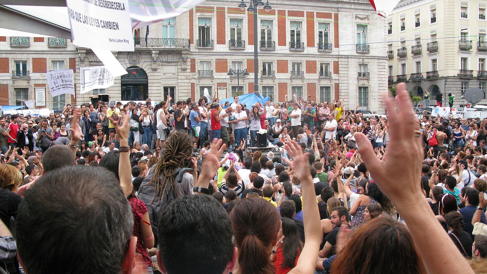 Los acampados vitorean a uno de los participantes del ágora de Sol.