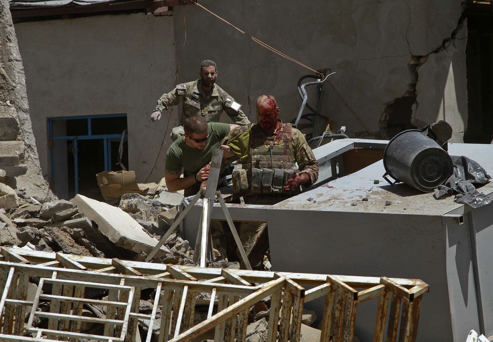 Un soldado italiano herido es ayudado por sus compañeros tras un atentado contra una base de la OTAN en Herat.