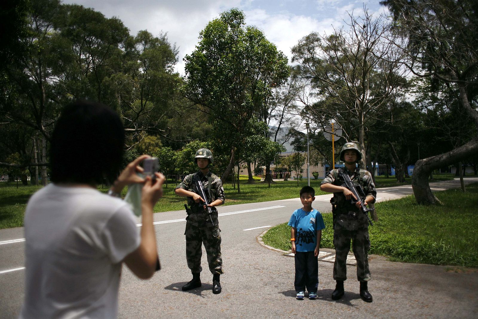 Una visitante toma una foto a su hijo junto a soldados del Ejército de Liberación Popular durante una jornada de puertas abiertas en Hong Kong