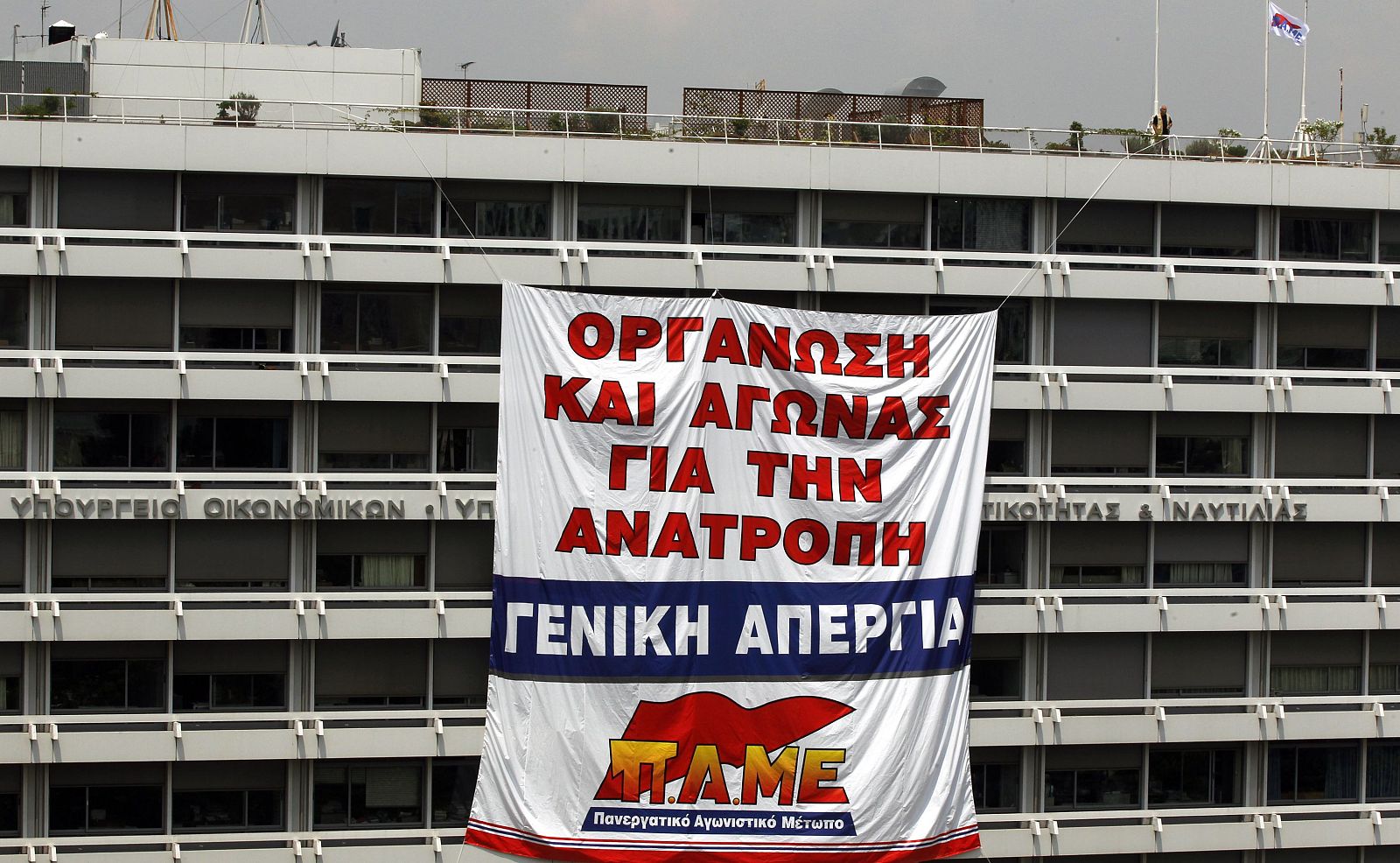 Pancarta desplegada por los trabajadores del PAME en el Ministro de Finanzas de Atenas