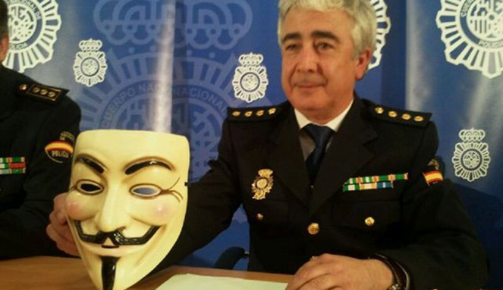 Un portavoz de la Policía Nacional muestra una de las caretas encontrada en casa de uno de los detenidos considerados como la 'cúpula' de Anonymous en España