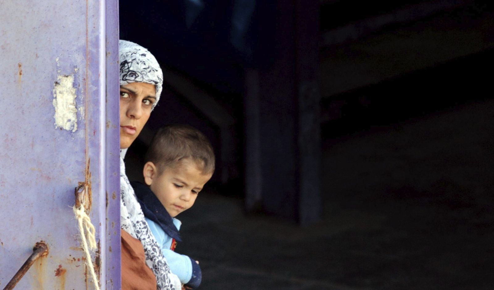 Una mujer y su hijo en el campo de refugiados sirios de Hatay (Turquía)