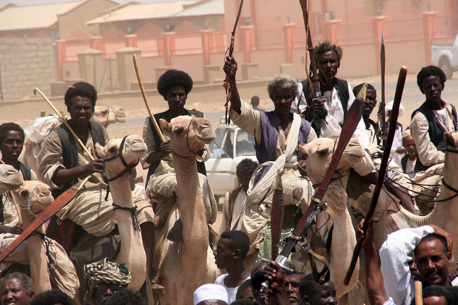 Un grupo de hombres montados en camellos da la bienvenida al presidente de Sudán Omar Hassan al-Bashir durante su visita a la ciudad de Sinkat.
