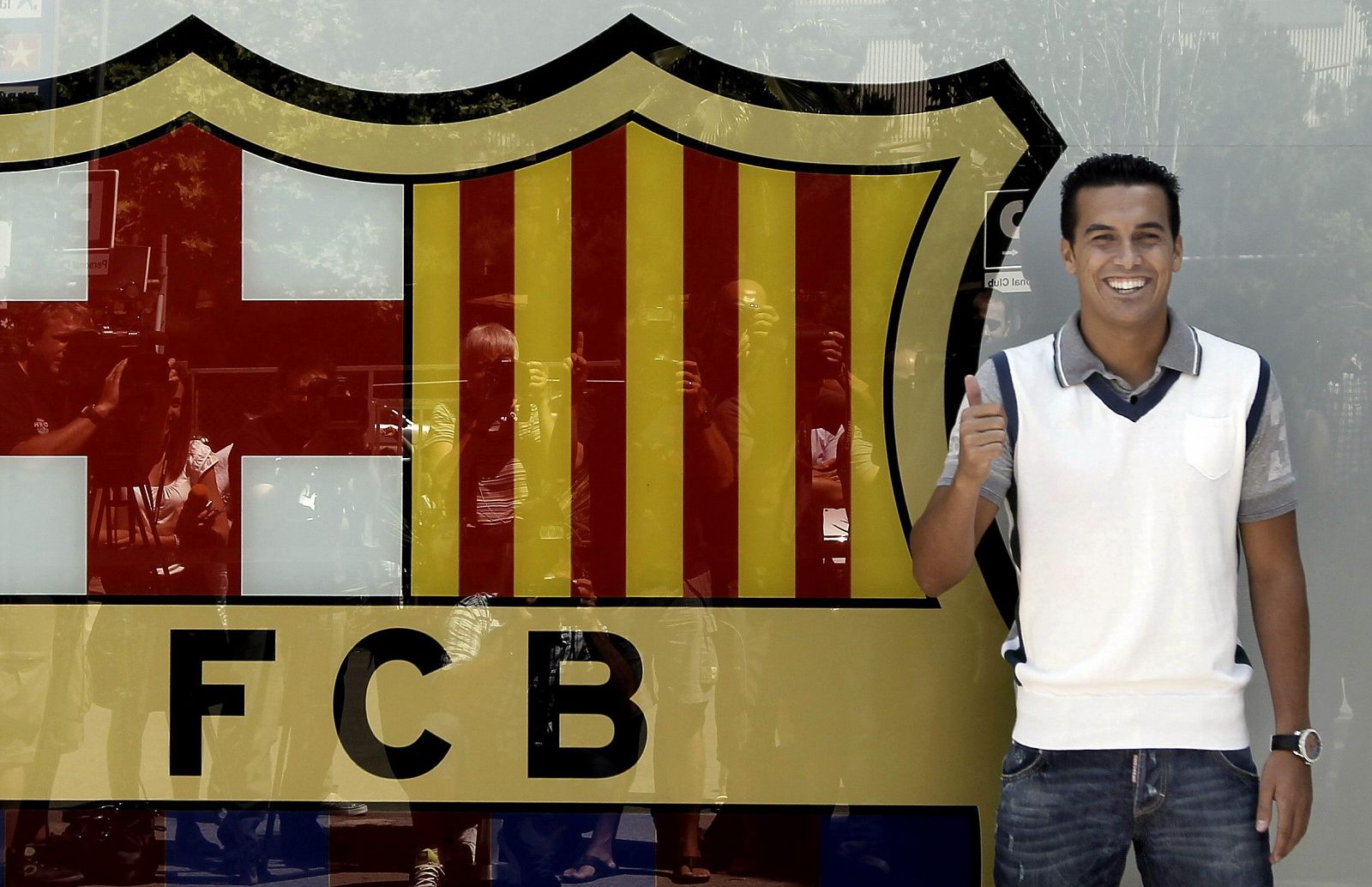 El delantero del FC Barcelona Pedro Rodríguez posa con el escudo del club, tras la firma de su nuevo contrato con el equipo azulgrana en el que militará hasta el año 2016