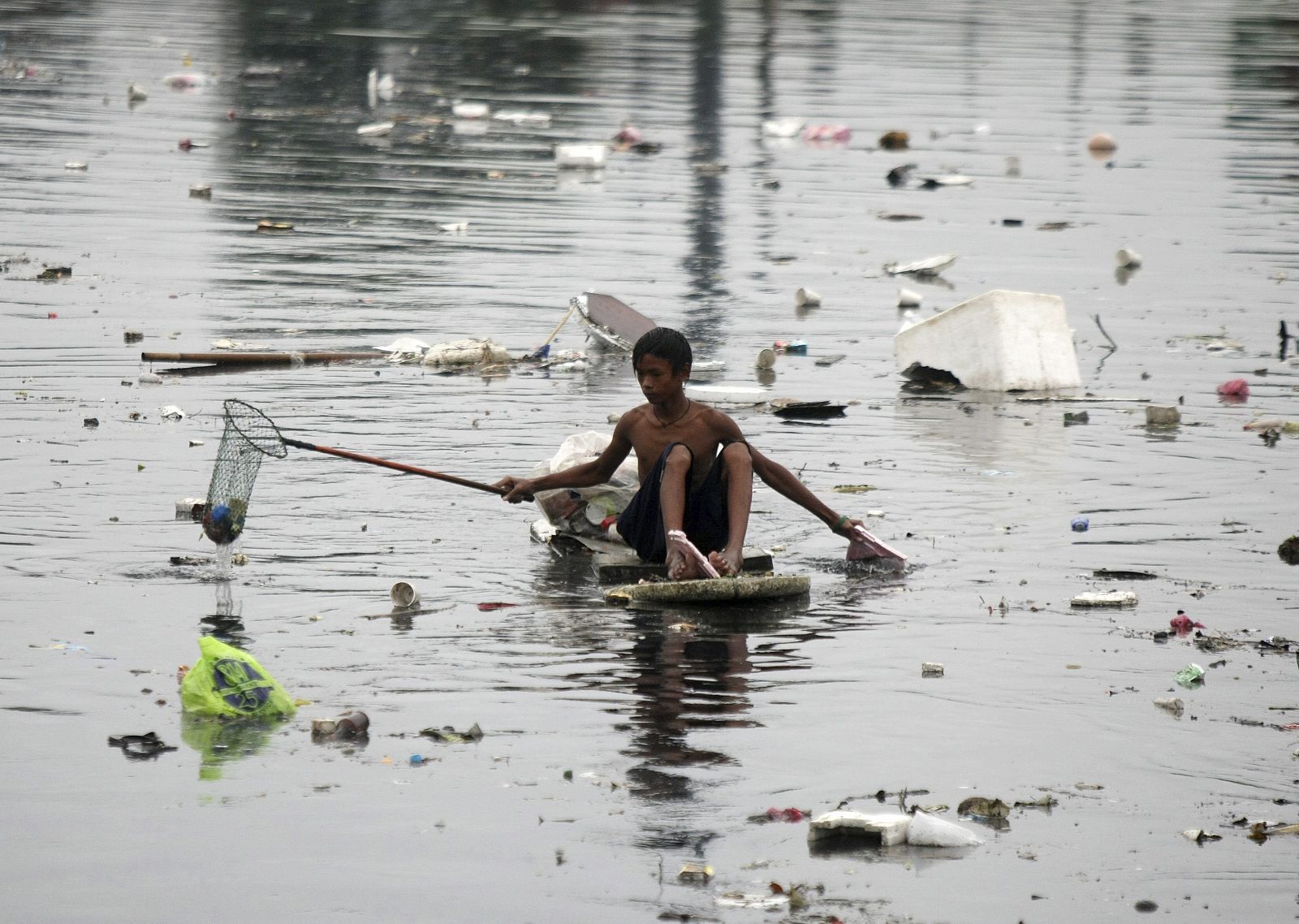 Un niño flota entre las aguas en la ciudad de Las Pinas, al sur de Manila