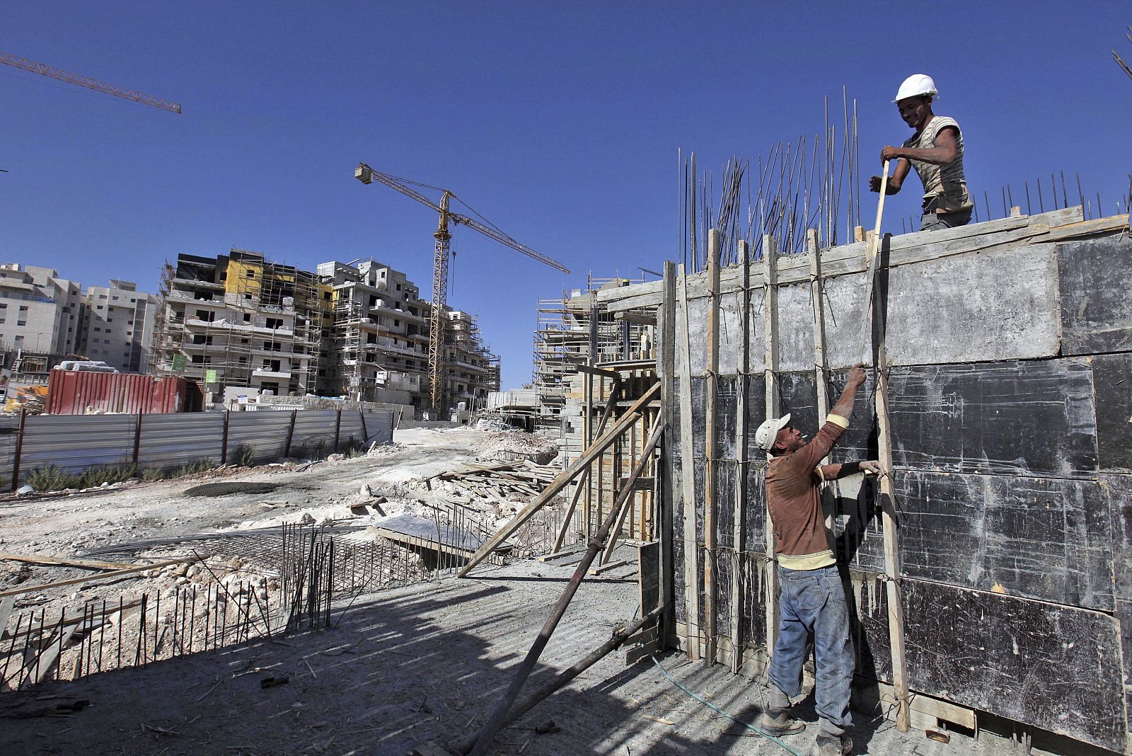 Obreros palestinos trabajan en la construcción de un edificio de viviendas, en la colonia judía de Har Homa, al sur de Jerusalén.