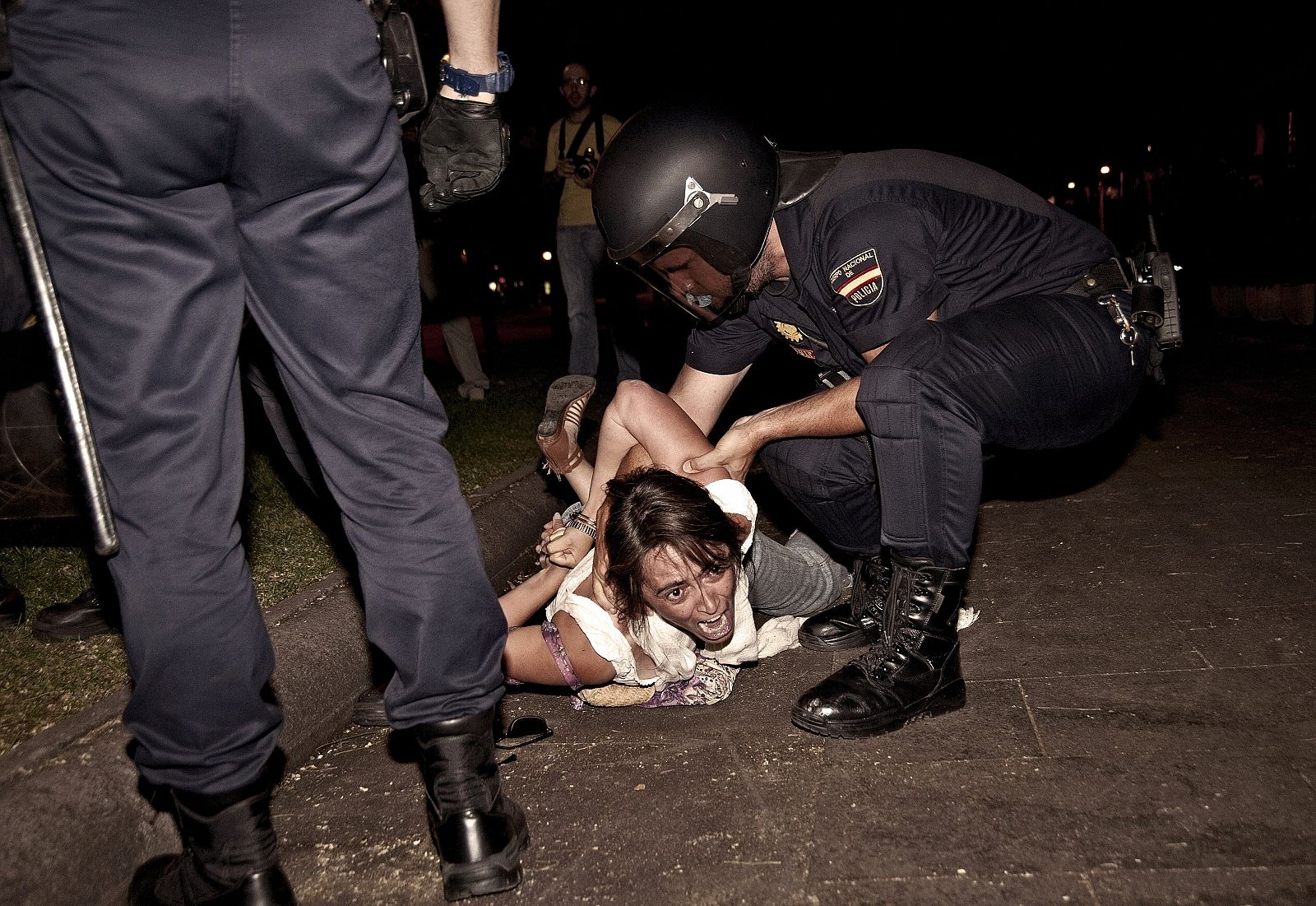 Los agentes inmovilizan a una mujer en la manifestación del 4 de agosto de 2011 frente a Interior.