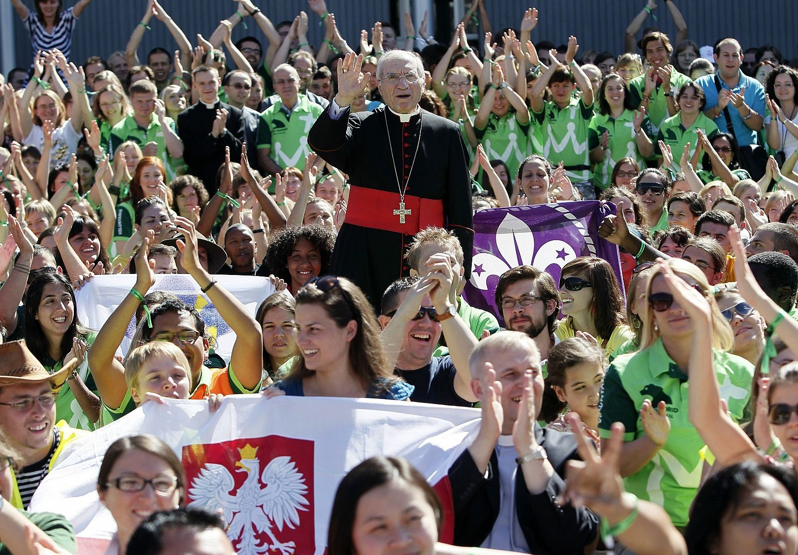 El cardenal y arzobispo de Madrid, Antonio María Rouco (c), rodeado de jóvenes tras oficiar una misa de acogida a los miles de voluntarios nacionales e internacionales.