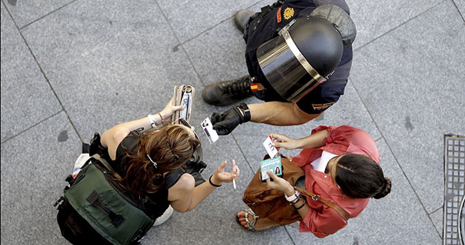 Un agente de Policía requiere la documentación a dos mujeres en un acceso a la Puerta del Sol de Madrid