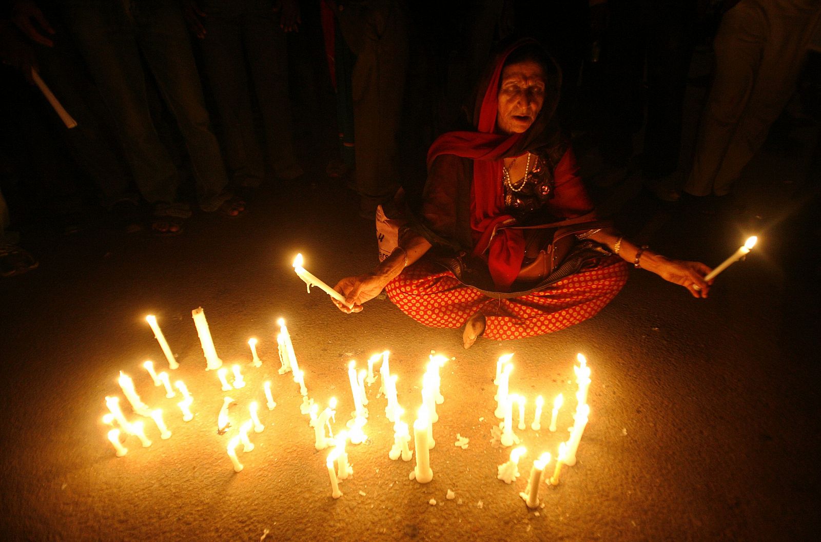 Una mujer participa en una vigilia con velas por el activista indio Anna Hazare en Nueva Delhi