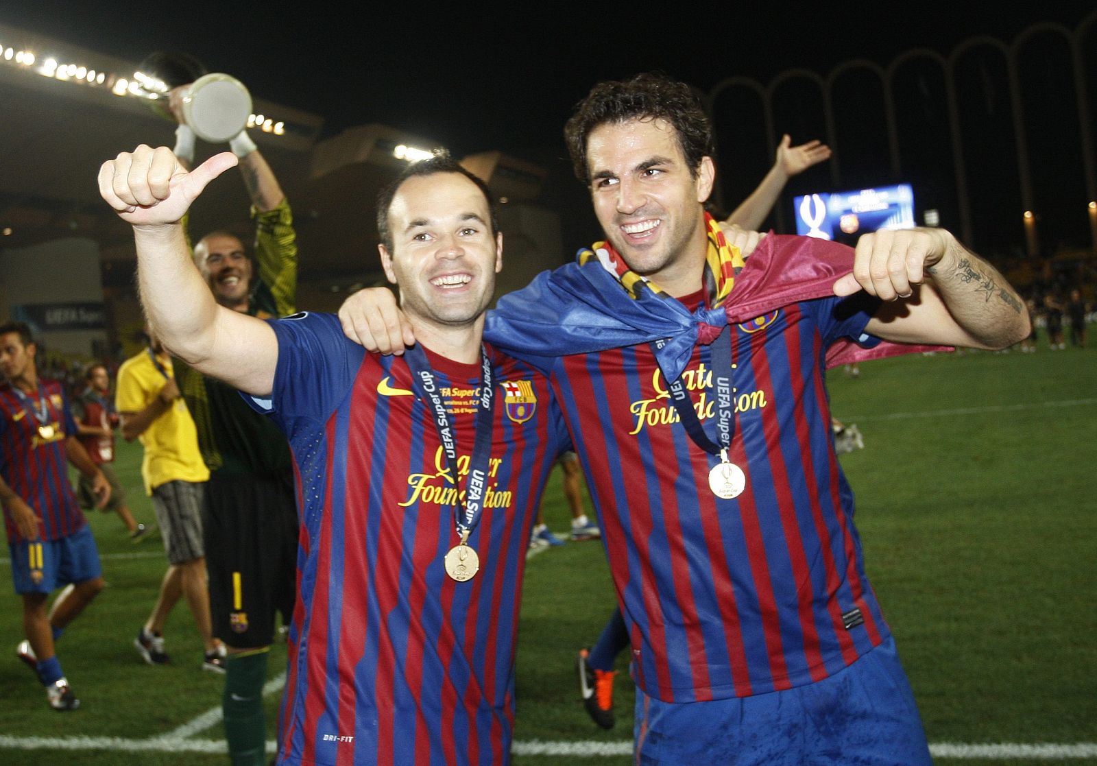 Barcelona's Andres Iniesta celebrates with Cesc Fabregas after their victory against Porto in their European Super Cup soccer match at Louis II stadium in Monaco