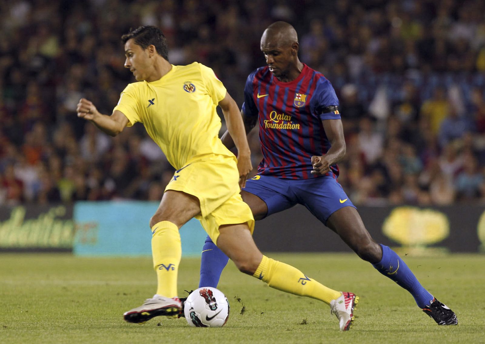 El defensa francés del FC Barcelona Eric Abidal (d) intenta arrebatar el balón al delantero brasileño del Villarreal Nilmar Honorato da Silva