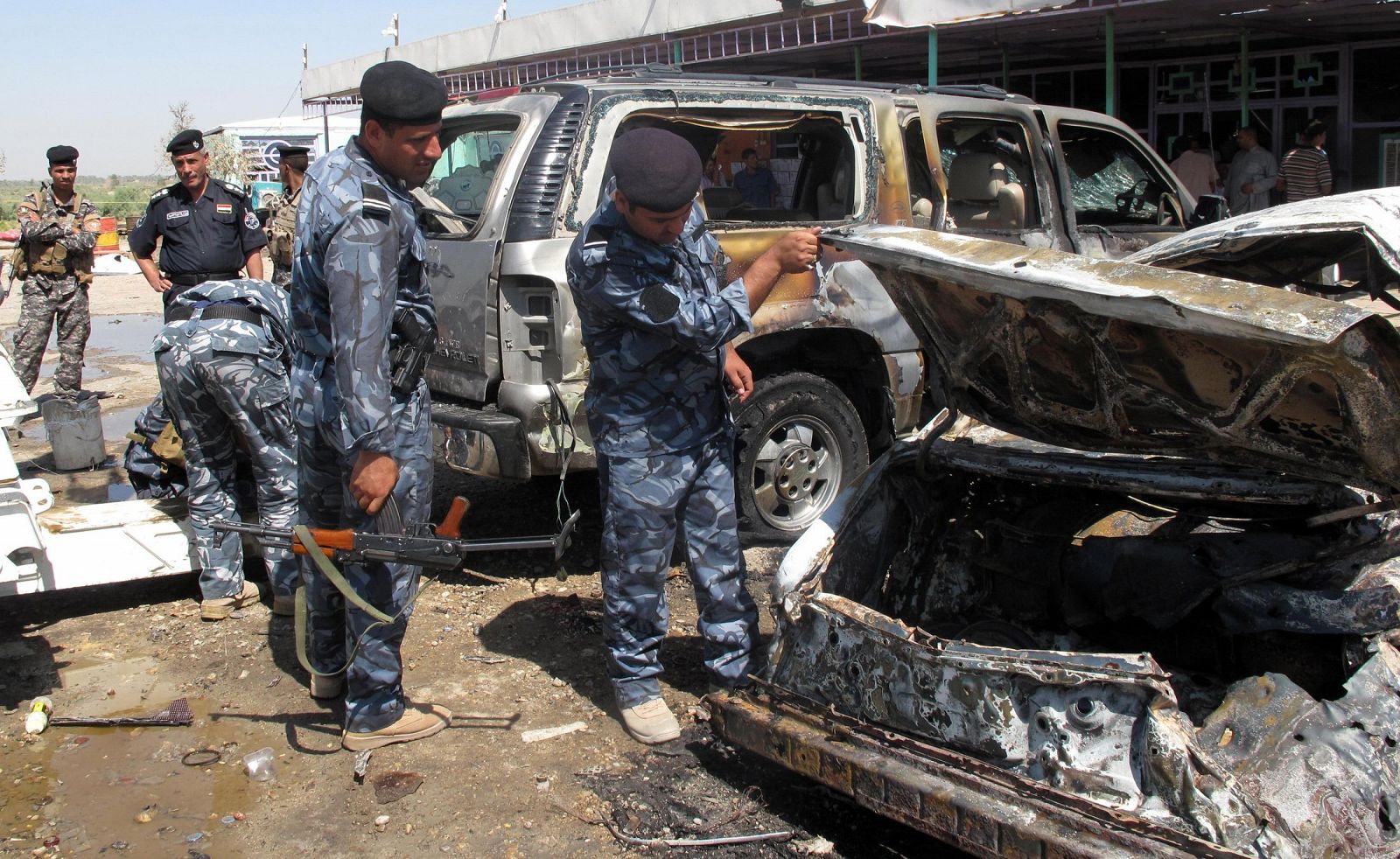 Policías iraquíes inspeccionan el lugar de la explosión que ha causado 15 muertos en Hamza