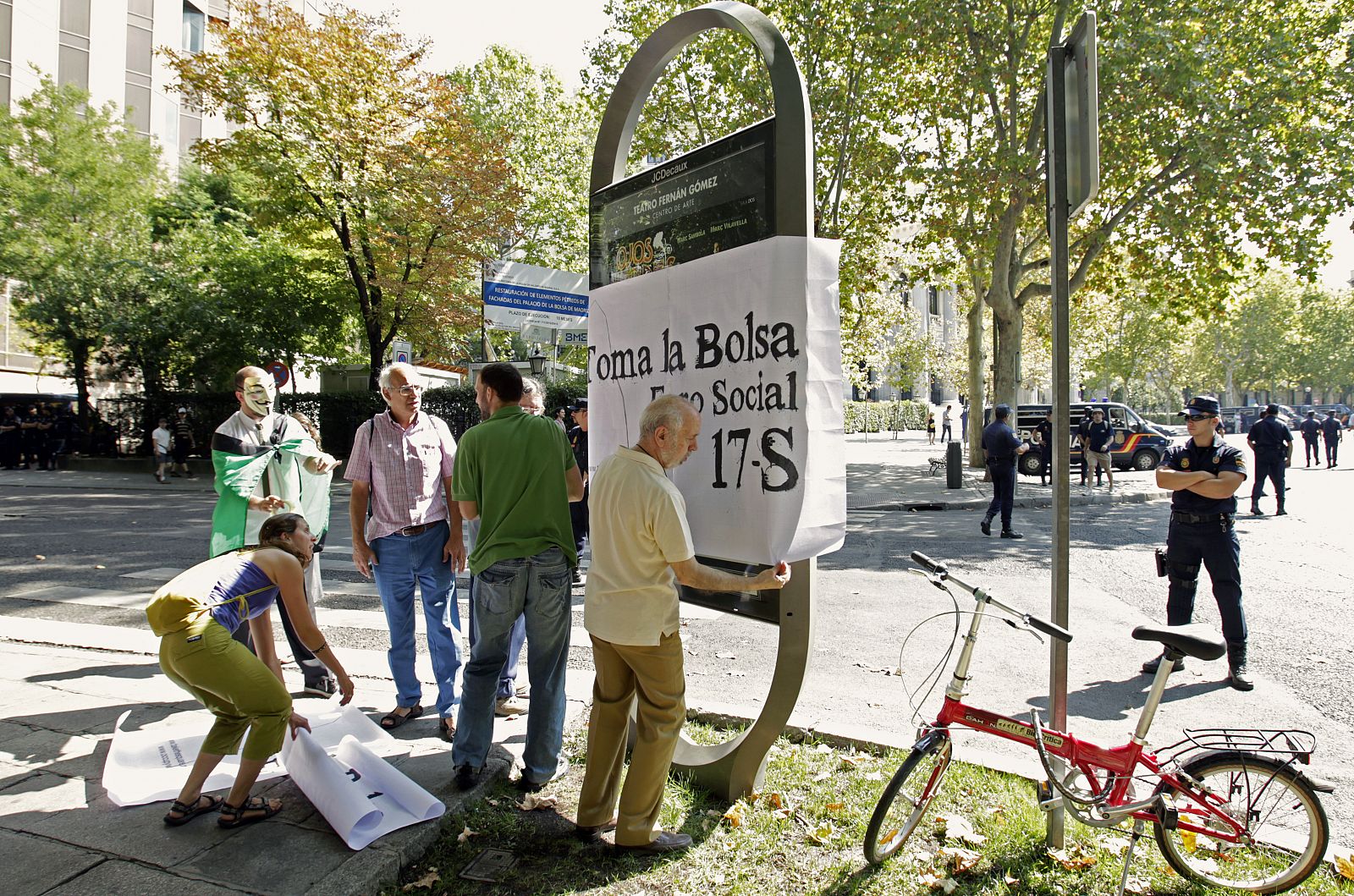 Activistas del movimiento "AcampadaSol-15M", durante la acción de protesta ante la sede de la Bolsa de Madrid