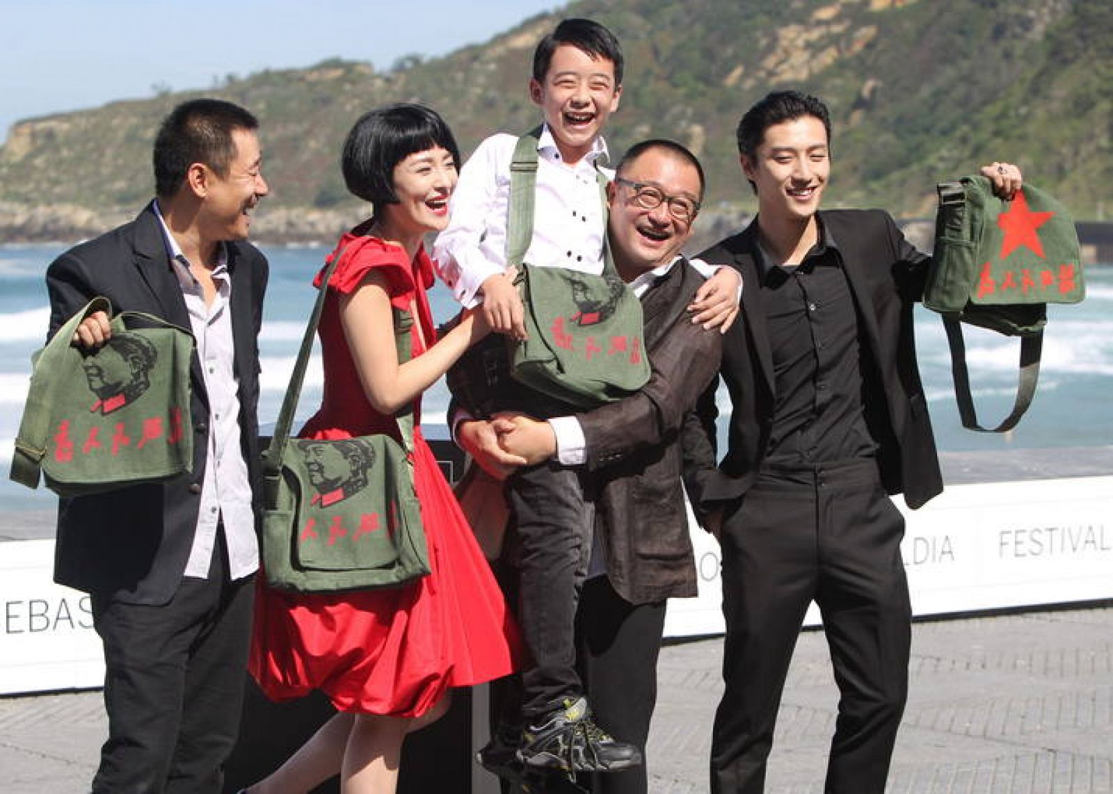 El realizador Wang Xiao Shuai, en el centro sosteniendo al niño, y los actores de "11 Flowers".