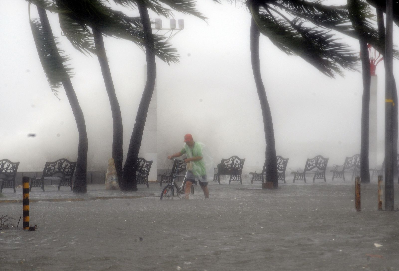 Un hombre hace frente al intenso viento que sacude la ciudad filipina de Manila